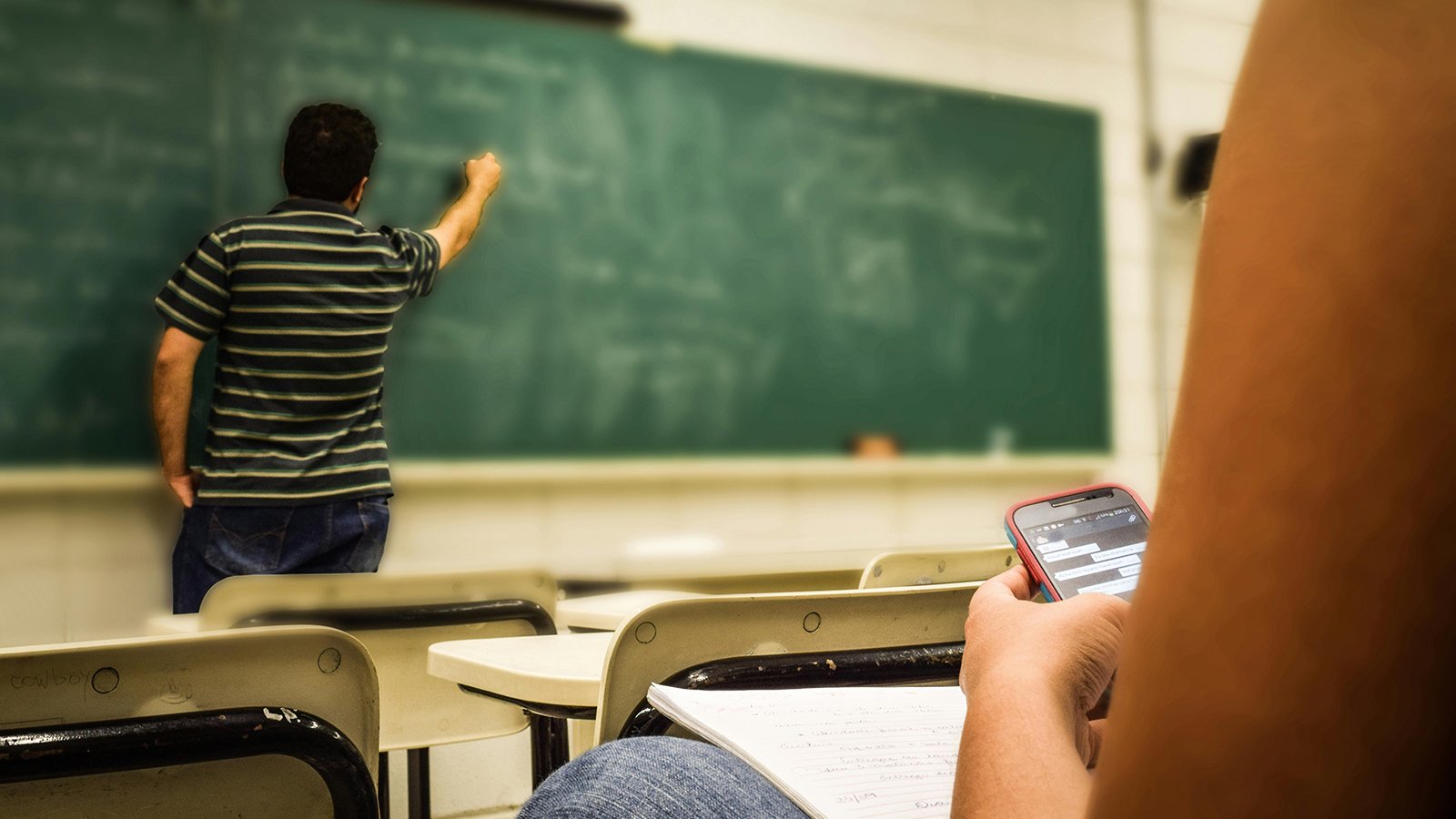 Teacher writing on a chalkboard